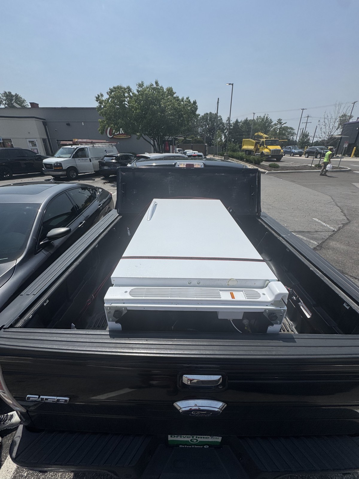 The same white freezer laid flat and strapped in the Cardinals Haul truck bed